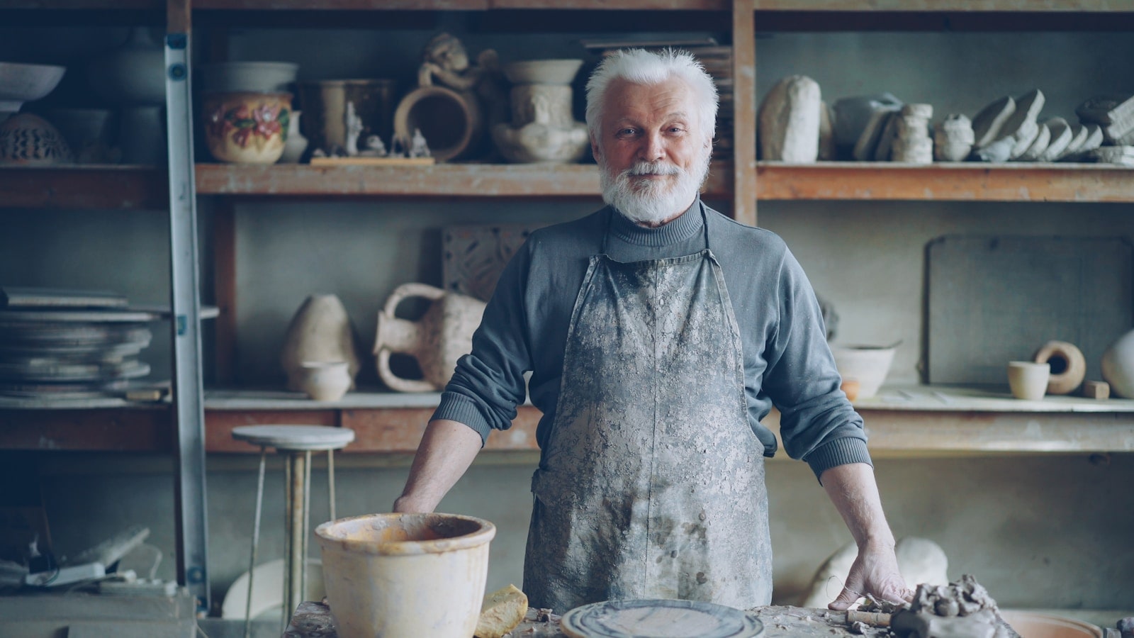 A craftsman standing in his pottery workshop